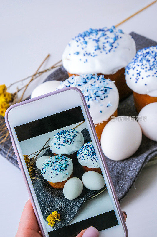 拍摄复活节蛋糕和彩蛋的女性手。复活节快乐。正统的节日。创意时尚潮流自制复活节蛋糕。Blogger Vlogger手机